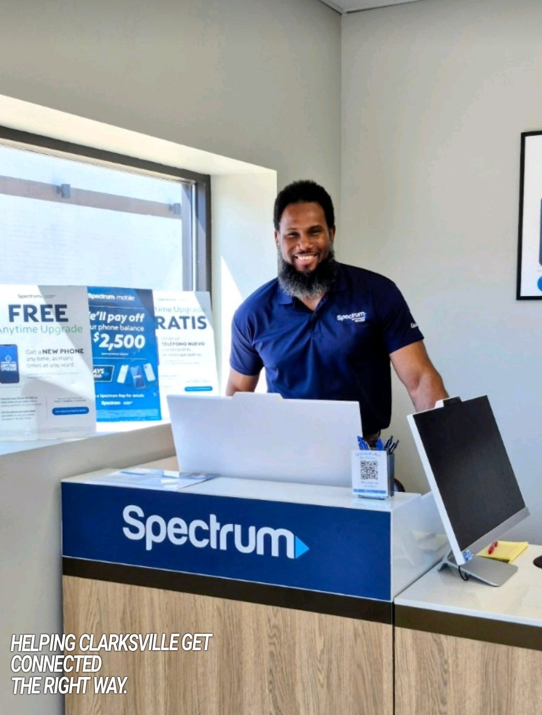 Demerus Davis behind the counter at Clarksville Internet Deals helping a customer with Spectrum setup