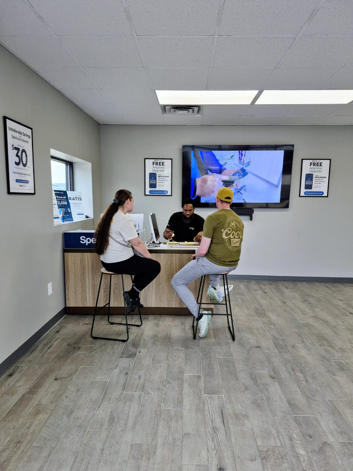 Demerus Davis helping two customers review their account at the Spectrum Premier Store desk in Clarksville
